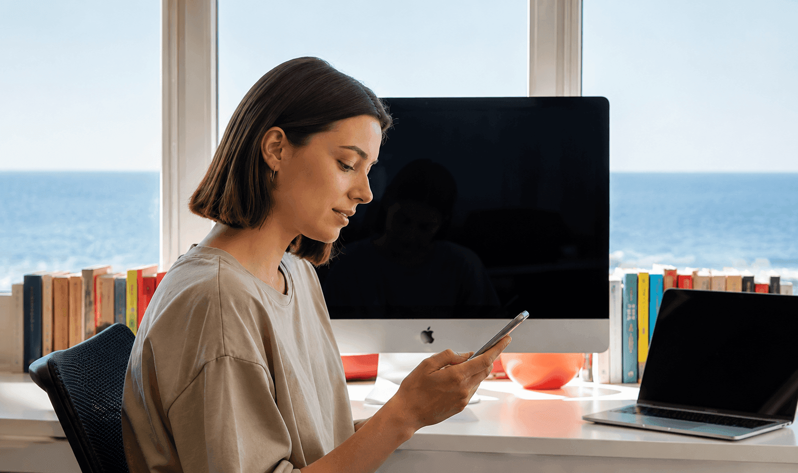 Person checking their phone while working at a desk