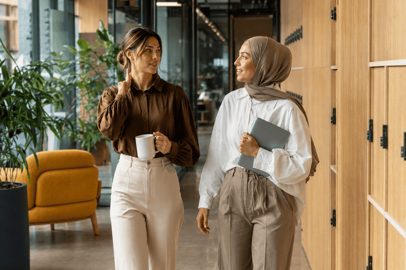 Two colleagues walking and talking in the office