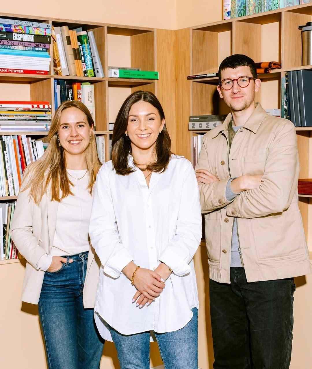 Three team members standing together in a creative office
